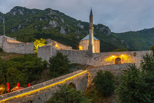 Historic Travnik Fortress and Colorful Mosque illuminating twilight, Bosnia and Herzegovina.