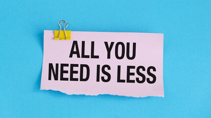 ALL YOU NEED IS LESS on pink paper on blue background