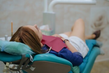The patient is lying in a dental chair. Treatment of the oral cavity and its prevention. Private dental clinic.