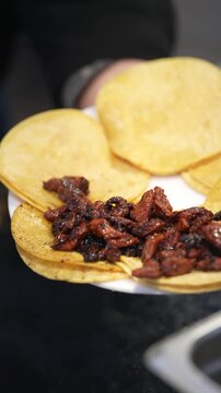 Pastor tacos being plated, vertical video in slow motion close up