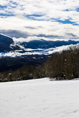 Obraz premium Saint-Julien-en-Vercors Plateau and the Southern Vercors mountains covered in snow in winter, seen from the ruins of La Goulandière hamlet in Rencurel