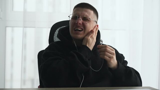 Ear infection due to listening to loud music on headphones.
A person removes headphones due to discomfort.
Damage from headphones