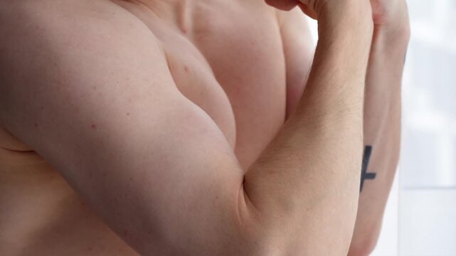 Arm muscles of an athlete.
A strong man shows off his arm muscles. Biceps and triceps on an athlete's arm.