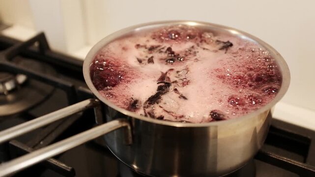 Close up of dyeing Easter eggs using natural hibiscus tea to create a deep blue marbled texture, eco-friendly DIY holiday traditions. Dyeing eggs with hibiscus creates stunning, natural shades.