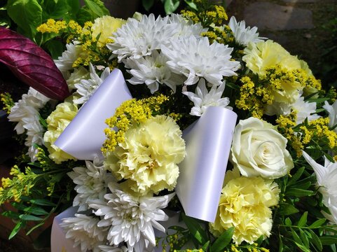 Blumengebinde am Grab auf dem Friedhof 