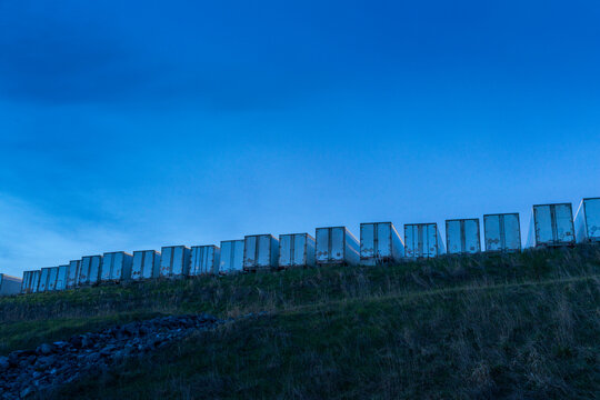 Canada, BC, Delta.  Line of truck trailers along the ridge of a hill.  Trucking company's parking area.