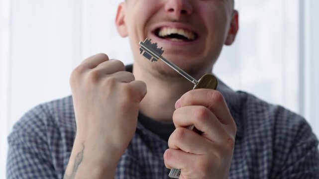 A man is overjoyed at the purchase of real estate.
A man with keys to an apartment is shouting with joy.
Buying a house