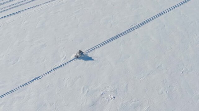 Drone Footage of Tracked Side by Side ATV Going Through Snow on Frozen Lake in Northeast USA
