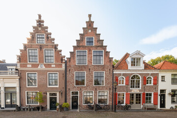 Fototapeta premium Row of historic Dutch houses with classic stepped gables and red shutters in the town of Edam, reflecting the traditional architectural style of the 17th century.
