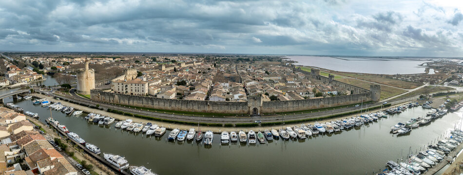 Aerial view of the medieval grid and terracotta rooftops within the historic walled city of Aigues-Mortes, Occitanie, France