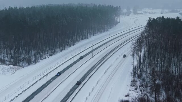Aerial perspective capturing snowy multilane road filled with moving trucks and flowing traffic