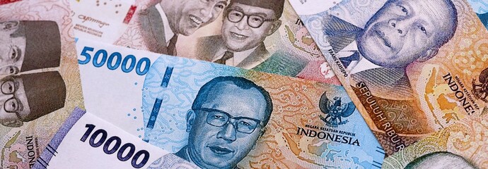 Indonesian rupiah money bills pile on table. Indonesia banknotes of IDR currency close up. Concept of business, economy and investment in Indonesia © Larysa