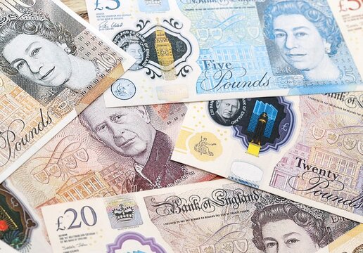 British pound money bills pile on table. United Kingdom banknotes of GBP currency close up. Concept of business, economy and investment in United Kingdom