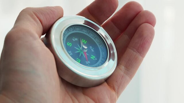 A compass in a person's hands.
A compass for determining direction while traveling.
Direction of travel