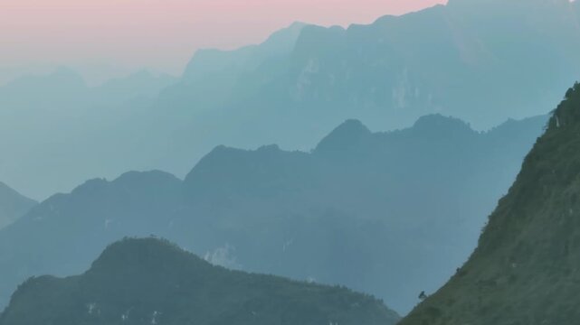 A scenic view of the misty mountains in Ha Giang, Vietnam. The image captures the serene beauty of the landscape at dawn, showcasing the natural beauty of the region.