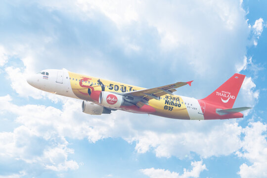 Phuket Thailand 12 02 2025: The plane flies against the clouds of a Thai AirAsia Airbus A320-216 with registration number HS-ABR In a special livery: Amazing New Chapters special coloring.