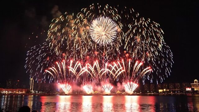 Colorful fireworks exploding over a modern city skyline at night.