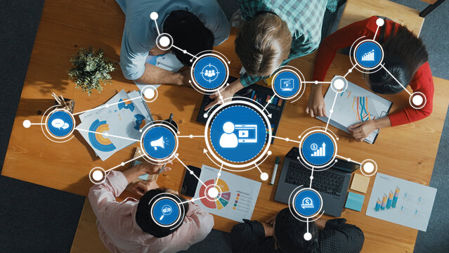 A dynamic team collaborates on marketing strategies, utilizing data visualizations and digital tools to enhance business growth and effectiveness in a modern workspace. Amity