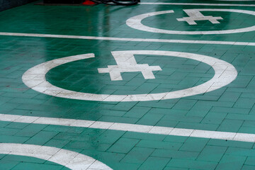 Bright green pavement features electric vehicle charging symbols, showcasing eco-friendly infrastructure in a bustling city environment