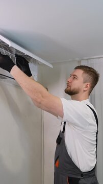 Technician removing dirty filter from air conditioner