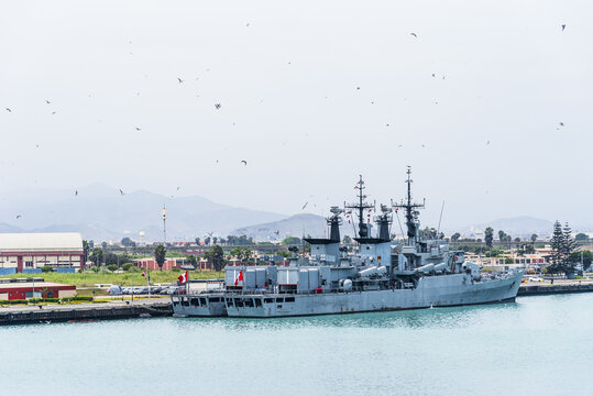 Military vessel docked at a harbor pier in Callao, Peru, viewed from the waterfront.
