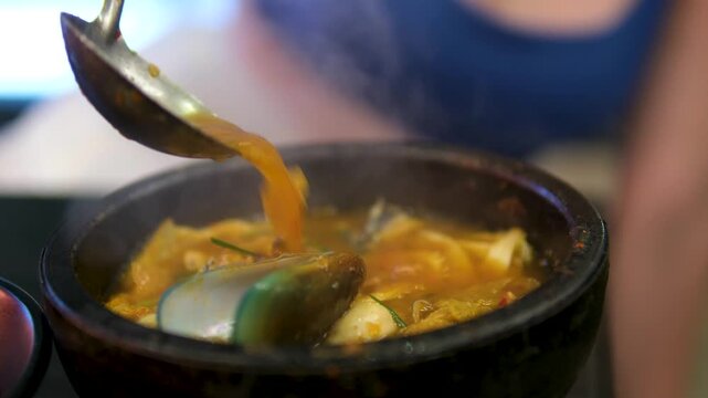 Seafood soup with mussels, shells, and tofu cheese Japanese Ramen with beef or chicken, rice noodles with fried meat, Tom Yum rotates on right background, close-up, vertical video. Spicy Thai Asian