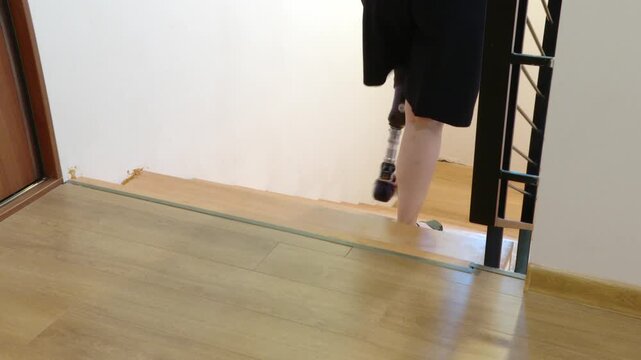 Woman with prosthetic leg walking down stairs