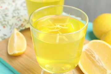 Yummy yellow jelly in dessert bowls and lemons on table, closeup