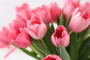 Obraz premium Bouquet of pink tulips on blurred light background, closeup