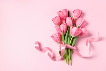 Fototapeta premium Bouquet of tulips on pink background, top view. Space for text