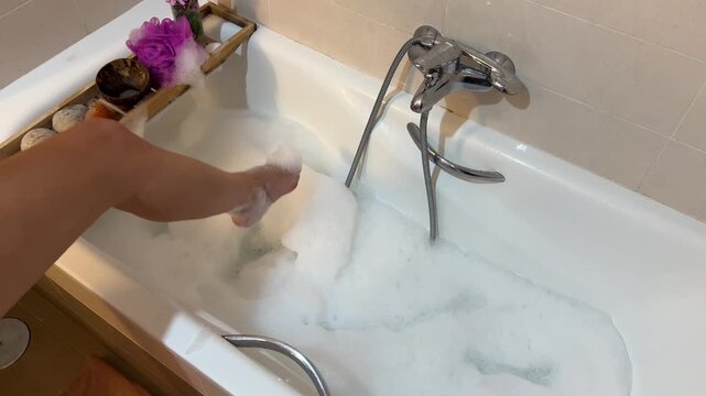 Mujer dejando la toalla y metiendo la pierna en la ba&ntilde;era