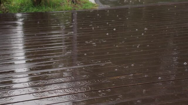 It's raining on the wooden floor outside