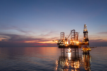Obraz premium Aerial view of offshore jack up rig in a shipyard during sunset for oil and gas exploration and production.