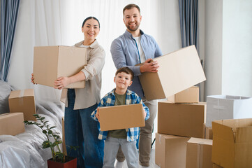 Happy family moving into new home holding boxes