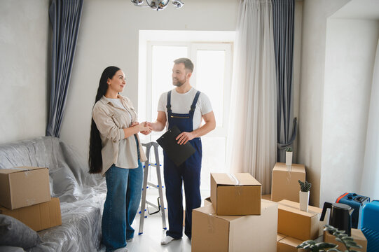 Woman homeowner shaking hands with professional mover