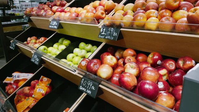 Interior of grocery store with fresh apples displayed on shelves, showcasing supermarket retail environment and everyday shopping experience. 