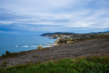 Rocky coastline and sandy beach with cliffs and ocean waves. High quality photo