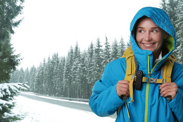 Obraz premium Happy woman with hidden camera and backpack on mountain road