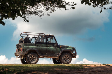 Off-road vehicle parked on hill against blue sky © Dima Sharapov