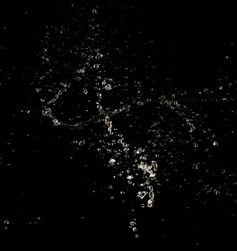 Crown water to object make curve drop explosion in ripple motion. Black background isolated. Crown Water splash on object to create shape form fluttering in droplet and wave.