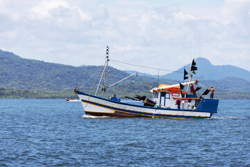 Obraz premium A fishing boat at sea photographed up close, mountains in the background