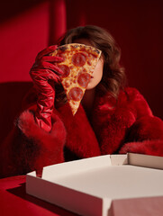 woman in red coat holding a pizza