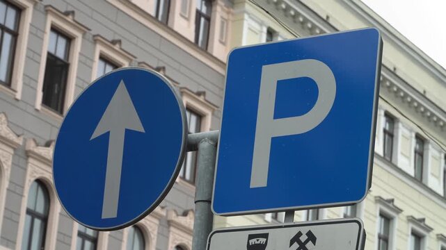 Directional traffic sign and parking sign in a street.