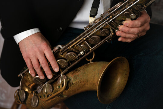 Close up of man's hands playing a tenor saxophone