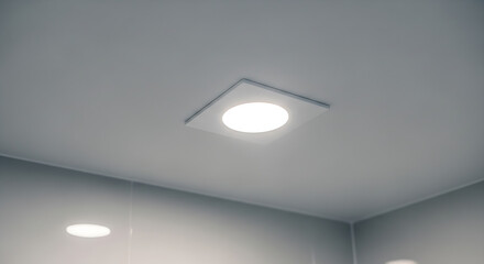 Recessed lighting fixture in ceiling with white walls and corner view