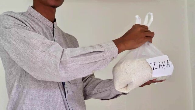 Muslim man hands over zakat fitrah rice