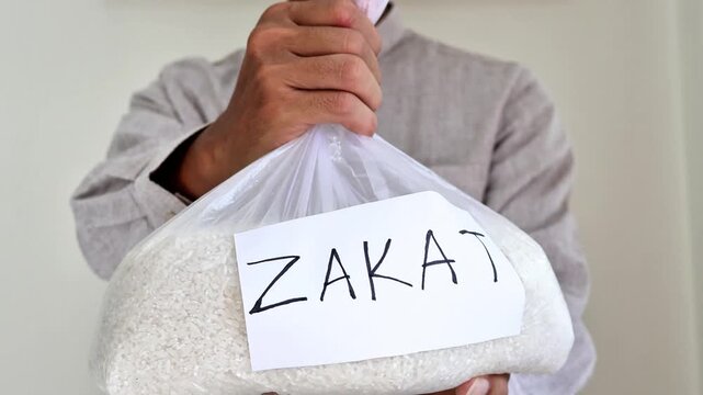 closeup Muslim man hands over zakat fitrah rice