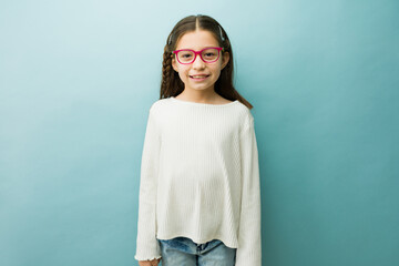 Little girl smiling and having fun. Happy child wearing corrective eyewear, promoting vision health...