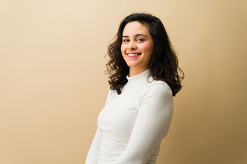 Smiling young woman posing in studio, expressing happiness and carefree casual lifestyle on