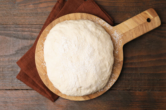 Fresh yeast dough on wooden table, top view